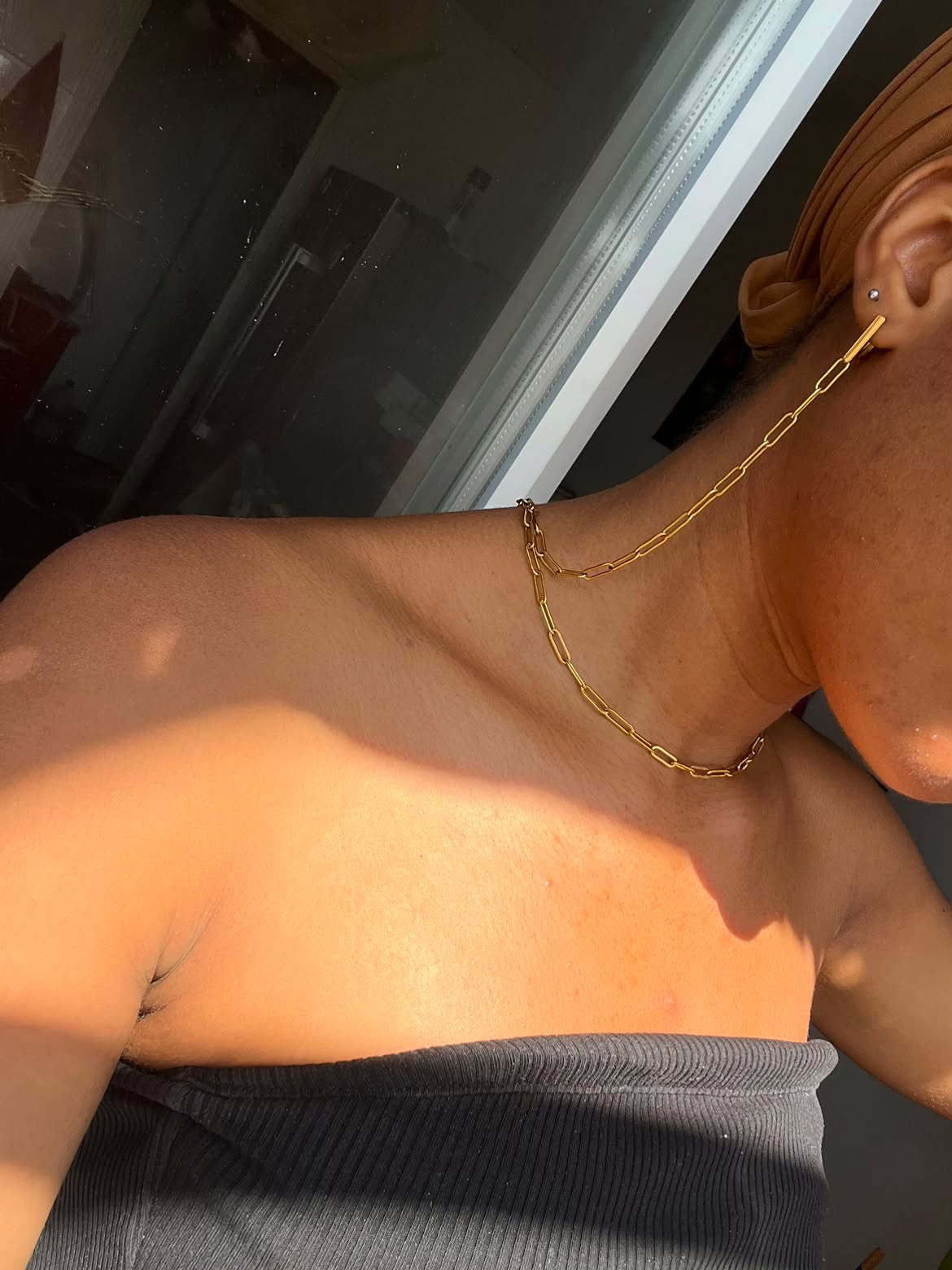 Bijou Byuvera porté : collier et boucle dorés sur la peau